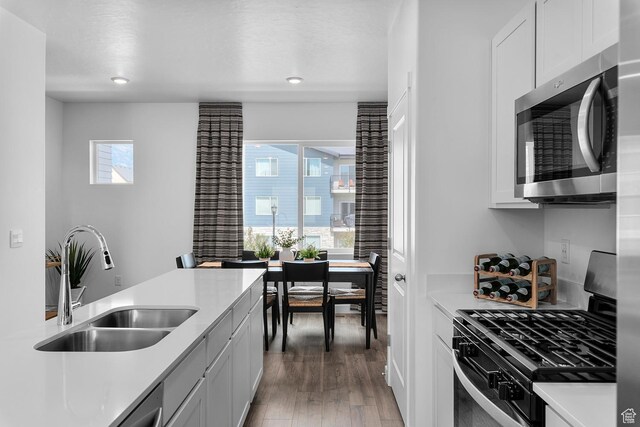 412 S 1110 W Unit 215, American Fork, UT 84003 - kitchen featuring appliances with stainless steel finishes, a sink, light wood-style flooring, light countertops, and white cabinets