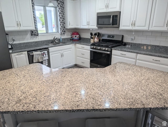 897 E 1200 N, Mapleton, UT 84664 - kitchen with stainless steel appliances, a sink, a breakfast bar, and white cabinetry