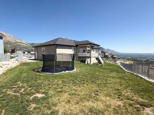 3723 N 500 E, North Ogden, UT 84414 - rear view of house with a trampoline, stucco siding, a mountain view, and stairway