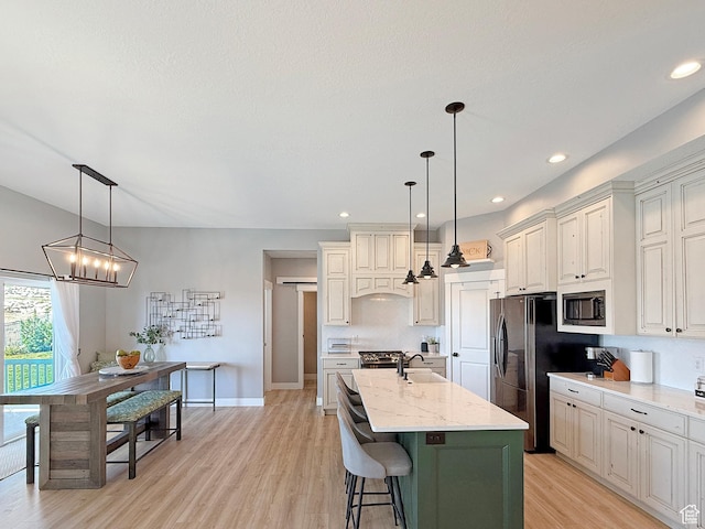 3723 N 500 E, North Ogden, UT 84414 - kitchen featuring stainless steel appliances, a sink, light wood-style floors, a center island with sink, and light stone countertops