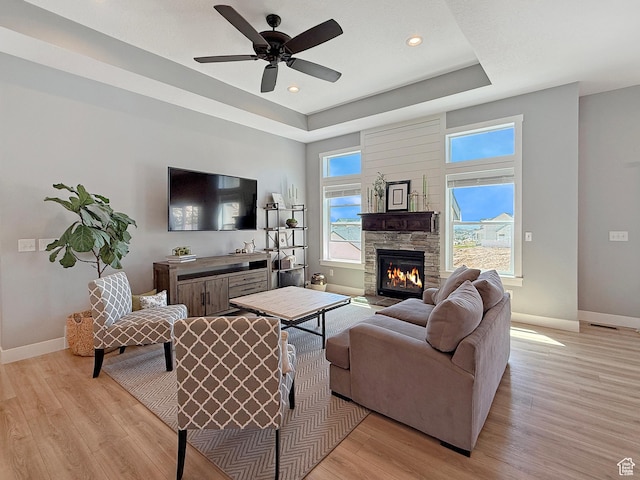 3723 N 500 E, North Ogden, UT 84414 - living room featuring baseboards, a tray ceiling, light wood finished floors, a stone fireplace, and recessed lighting