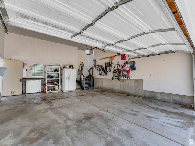 10685 S Superior Cir E, Sandy, UT 84094 - garage with a garage door opener and white fridge with ice dispenser
