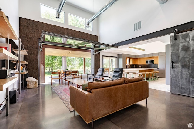 1983 W Ranch Rd, Farmington, UT 84025 - living room featuring a high ceiling, finished concrete floors, and plenty of natural light