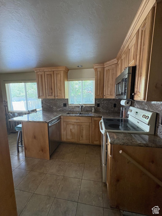 9835 S 610 E, Sandy, UT 84070 - kitchen featuring appliances with stainless steel finishes, a sink, healthy amount of natural light, decorative backsplash, and a textured ceiling