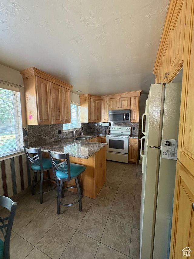 9835 S 610 E, Sandy, UT 84070 - kitchen featuring white appliances, decorative backsplash, a peninsula, a sink, and light tile patterned floors