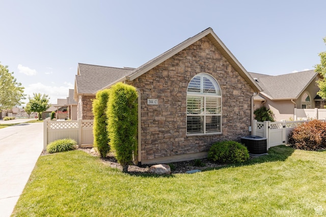 344 E 2280 N Unit C, North Logan, UT 84341 - view of home's exterior with stone siding, cooling unit, and roof with shingles