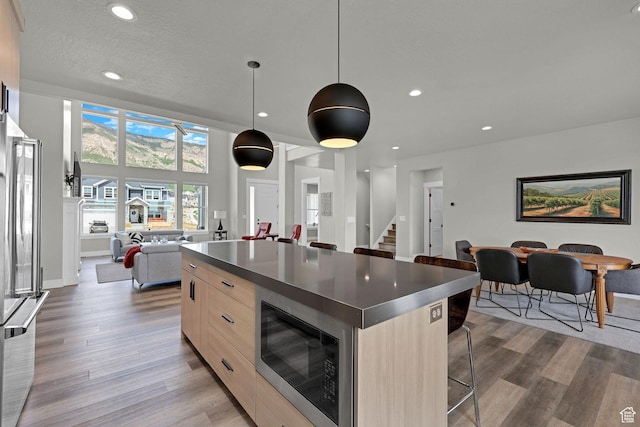 3877 N 425 E, North Ogden, UT 84414 - kitchen featuring modern cabinets, built in microwave, light brown cabinets, open floor plan, and a center island