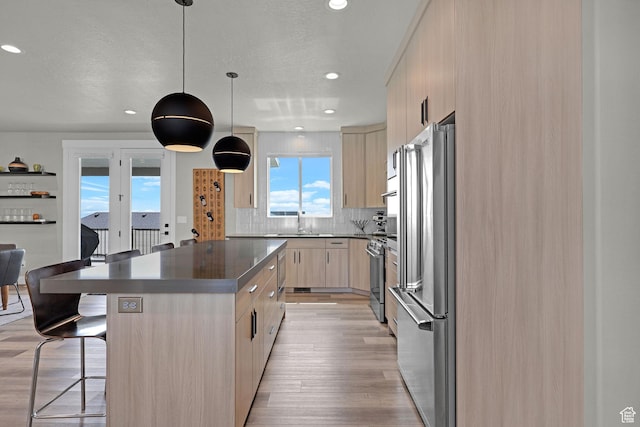3877 N 425 E, North Ogden, UT 84414 - kitchen featuring stainless steel appliances, light brown cabinetry, a kitchen bar, a sink, and modern cabinets