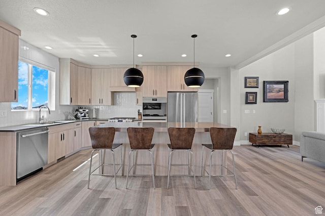 3877 N 425 E, North Ogden, UT 84414 - kitchen featuring stainless steel appliances, light brown cabinets, light wood finished floors, a sink, and a center island
