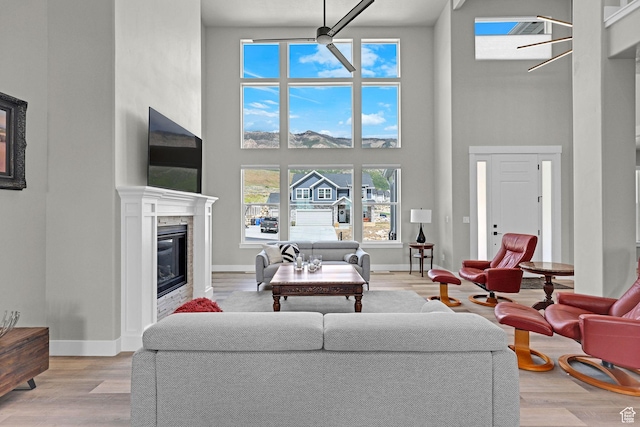3877 N 425 E, North Ogden, UT 84414 - living room with a towering ceiling, a glass covered fireplace, light wood-type flooring, and baseboards
