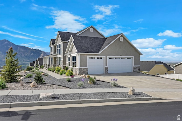 3877 N 425 E, North Ogden, UT 84414 - view of front of home with stucco siding, stone siding, an attached garage, driveway, and a mountain view