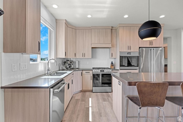 3877 N 425 E, North Ogden, UT 84414 - kitchen with appliances with stainless steel finishes, light brown cabinets, a sink, a kitchen breakfast bar, and light wood-type flooring