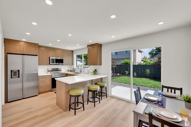 1210 E Bonner Way S, Millcreek, UT 84117 - kitchen featuring stainless steel appliances, a sink, recessed lighting, light wood-style floors, and a kitchen bar