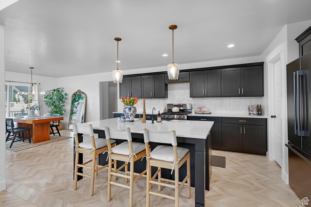 4609 N Kings Peak Way Unit 912, Eagle Mountain, UT 84005 - kitchen with stainless steel gas stove, high quality fridge, light countertops, backsplash, and an island with sink