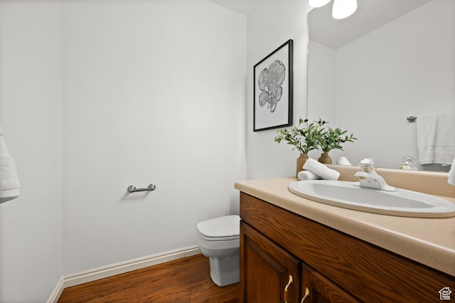 12563 S Bear Castle Cv, Draper, UT 84020 - half bath featuring vanity, toilet, wood finished floors, and baseboards