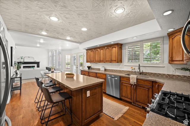 12563 S Bear Castle Cv, Draper, UT 84020 - kitchen with stainless steel dishwasher, a sink, an ornate ceiling, a kitchen island, and range