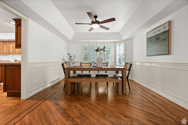 12563 S Bear Castle Cv, Draper, UT 84020 - dining area featuring a ceiling fan, a raised ceiling, light wood-type flooring, and a wainscoted wall