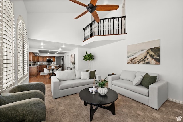 12563 S Bear Castle Cv, Draper, UT 84020 - living area with a towering ceiling, a ceiling fan, and baseboards