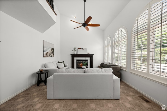 12563 S Bear Castle Cv, Draper, UT 84020 - carpeted living room with ceiling fan, a tiled fireplace, high vaulted ceiling, and baseboards