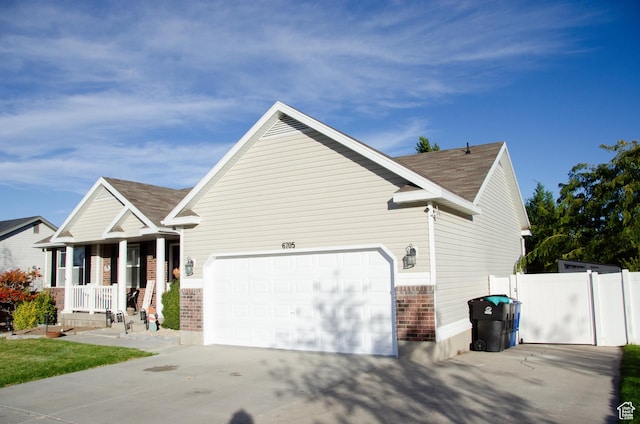 6705 S High Bluff Dr W, West Jordan, UT 84081 - view of side of property with brick siding, an attached garage, concrete driveway, a porch, and a shingled roof