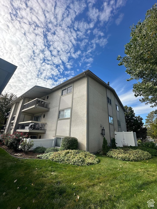 4853 S Woodbridge Dr E Unit 44, Salt Lake City, UT 84117 - view of property exterior with stucco siding and a lawn
