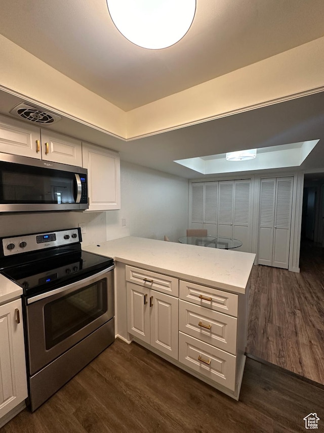 4853 S Woodbridge Dr E Unit 44, Salt Lake City, UT 84117 - kitchen featuring appliances with stainless steel finishes, dark wood-style flooring, white cabinetry, and a peninsula