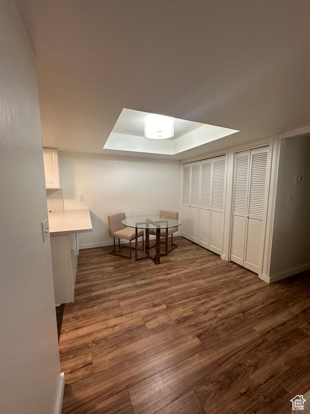 4853 S Woodbridge Dr E Unit 44, Salt Lake City, UT 84117 - dining space featuring dark wood-style flooring, a raised ceiling, and baseboards