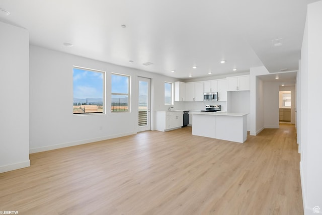 5263 W Reventon Rd S, South Jordan, UT 84009 - unfurnished living room with light wood-style floors and recessed lighting