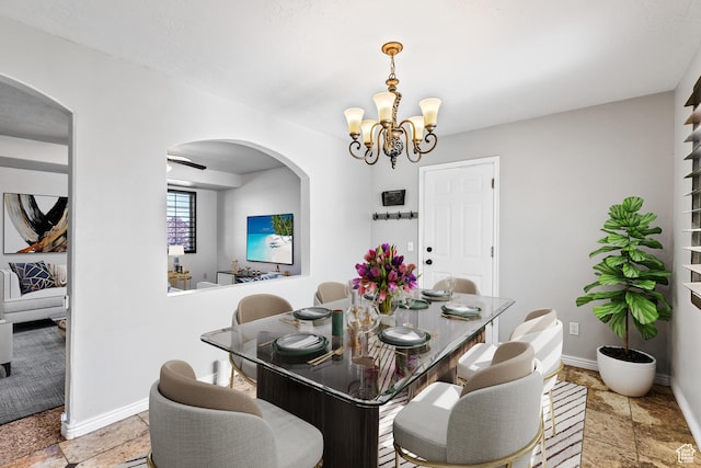 748 N 310 E, Tooele, UT 84074 - dining room with arched walkways, a chandelier, baseboards, and stone tile floors