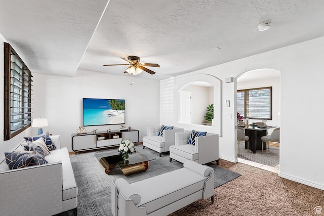 748 N 310 E, Tooele, UT 84074 - carpeted living room with a textured ceiling, a ceiling fan, arched walkways, and baseboards