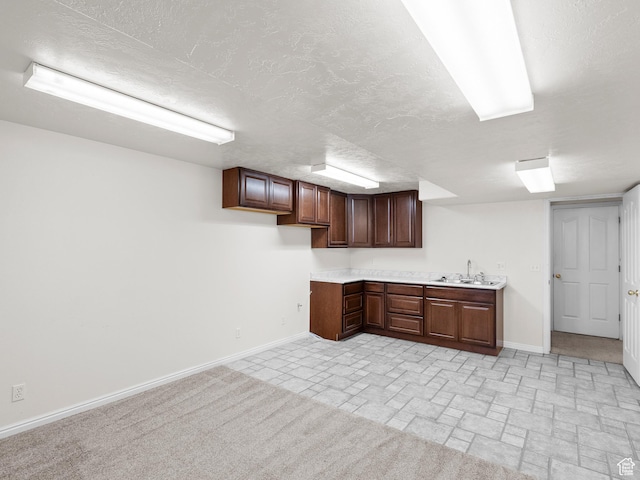 4912 W Rosewood Dr S, South Jordan, UT 84009 - kitchen featuring a sink, baseboards, light countertops, a textured ceiling, and dark brown cabinetry