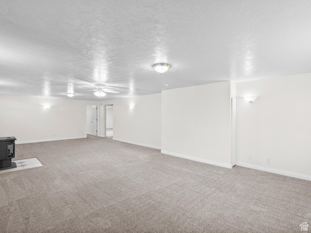 4912 W Rosewood Dr S, South Jordan, UT 84009 - below grade area featuring a wood stove, a ceiling fan, carpet floors, a textured ceiling, and baseboards