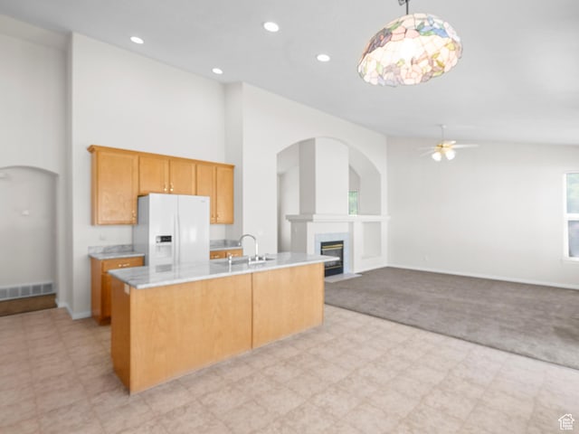 4912 W Rosewood Dr S, South Jordan, UT 84009 - kitchen with white refrigerator with ice dispenser, ceiling fan, a fireplace with flush hearth, light countertops, and a center island with sink