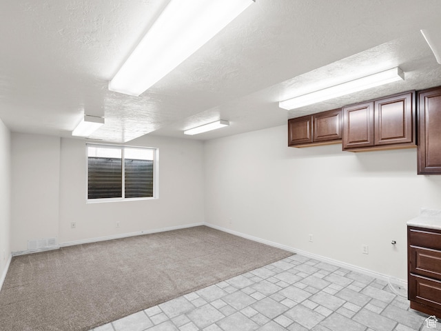 4912 W Rosewood Dr S, South Jordan, UT 84009 - below grade area with a textured ceiling, baseboards, brick patterned flooring, and light colored carpet