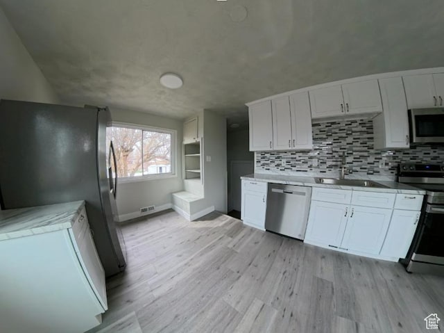 197 W Center St, Midvale, UT 84047 - kitchen with stainless steel appliances, a sink, light wood-style floors, and white cabinets