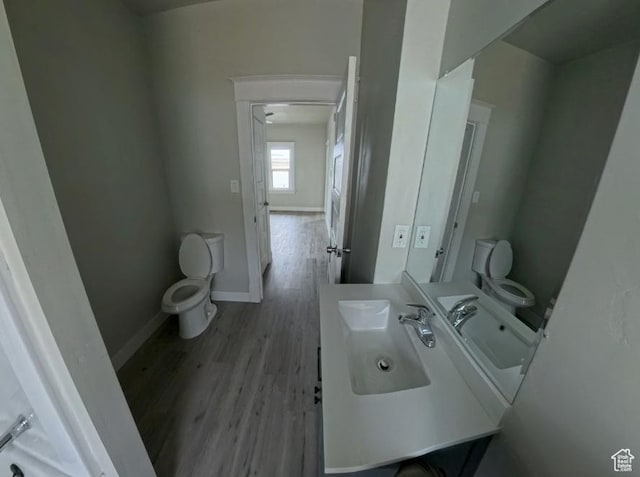 197 W Center St, Midvale, UT 84047 - bathroom with toilet, wood finished floors, baseboards, and vanity