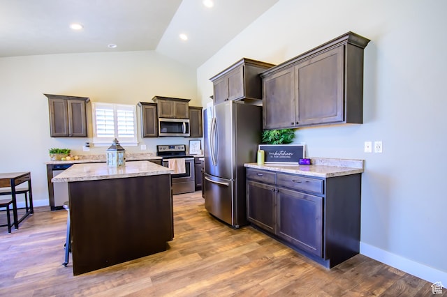 534 S Chan Dr, Grantsville, UT 84029 - kitchen featuring stainless steel appliances, vaulted ceiling, a kitchen island, dark brown cabinets, and light stone counters