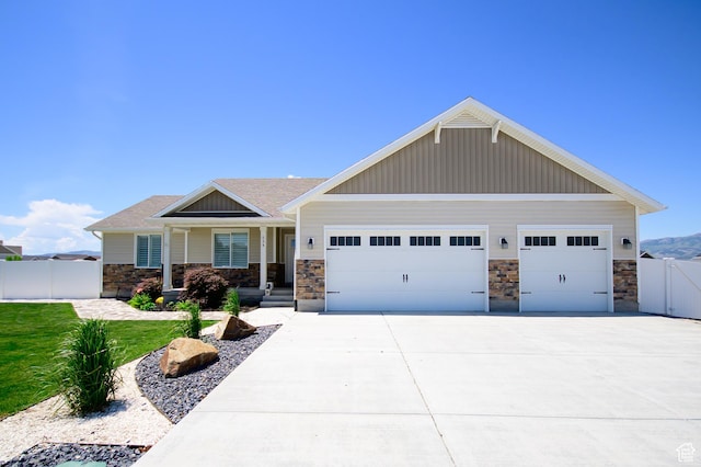 534 S Chan Dr, Grantsville, UT 84029 - craftsman-style home with stone siding, a garage, a gate, driveway, and board and batten siding