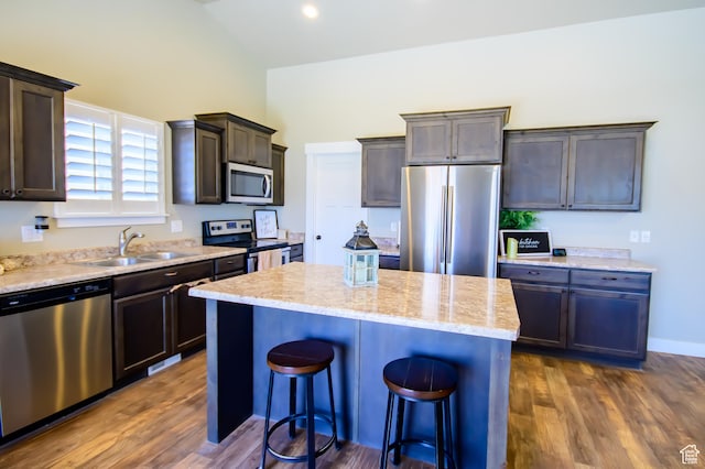 534 S Chan Dr, Grantsville, UT 84029 - kitchen featuring appliances with stainless steel finishes, a sink, dark brown cabinetry, a kitchen breakfast bar, and a center island