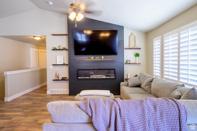 534 S Chan Dr, Grantsville, UT 84029 - living area with lofted ceiling, wood finished floors, ceiling fan, a glass covered fireplace, and baseboards