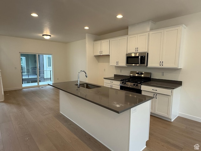 814 W 490 S Unit 329, American Fork, UT 84003 - kitchen featuring appliances with stainless steel finishes, a sink, dark countertops, light wood-style flooring, and recessed lighting