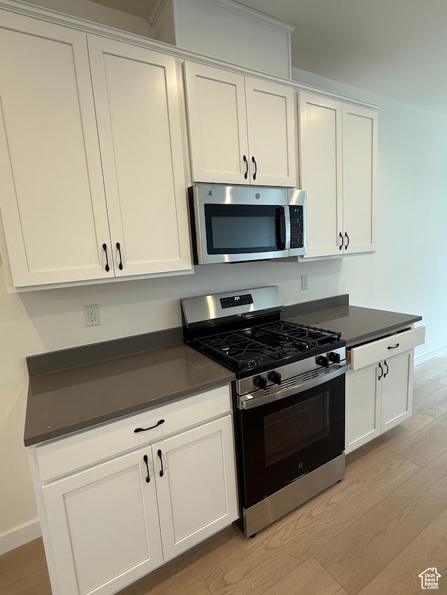 814 W 490 S Unit 329, American Fork, UT 84003 - kitchen featuring stainless steel appliances, dark countertops, light wood-style floors, and white cabinets