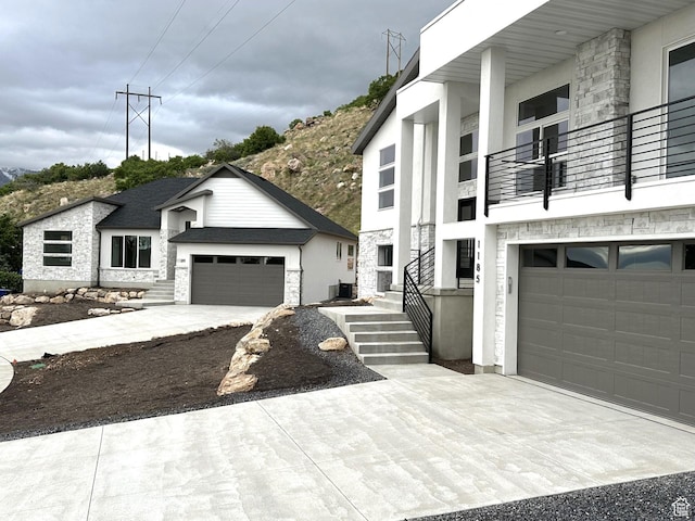 1189 E Benchview Dr, Ogden, UT 84404 - contemporary home featuring stone siding, a balcony, concrete driveway, and stucco siding