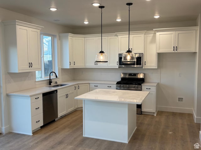 718 N 280 E, Tooele, UT 84074 - kitchen featuring stainless steel appliances, a sink, white cabinets, wood finished floors, and baseboards