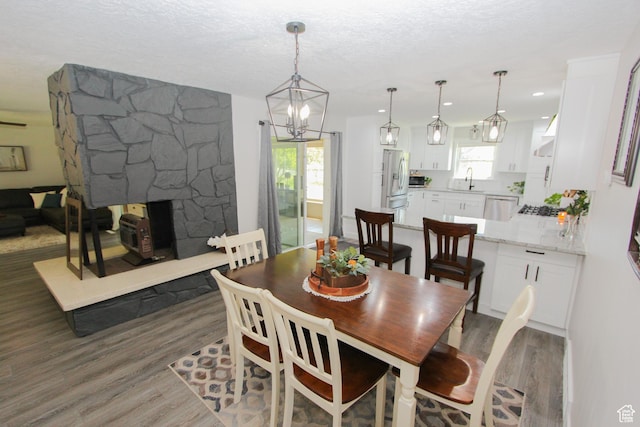 1460 E 2100 N, North Logan, UT 84341 - dining area with wood finished floors, a stone fireplace, a chandelier, and a textured ceiling