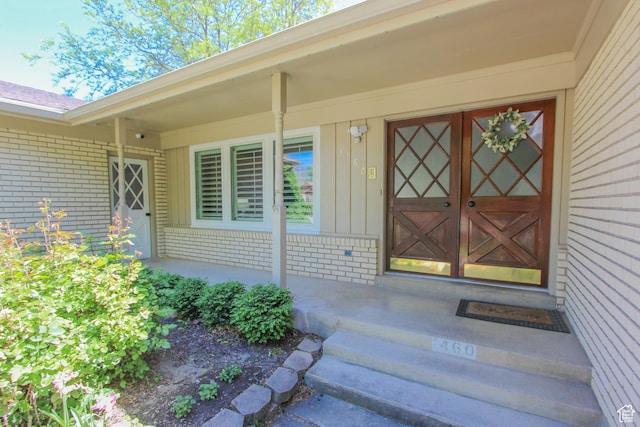 1460 E 2100 N, North Logan, UT 84341 - doorway to property with brick siding, a porch, and board and batten siding