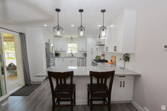 1460 E 2100 N, North Logan, UT 84341 - kitchen featuring appliances with stainless steel finishes, a sink, a peninsula, white cabinetry, and backsplash