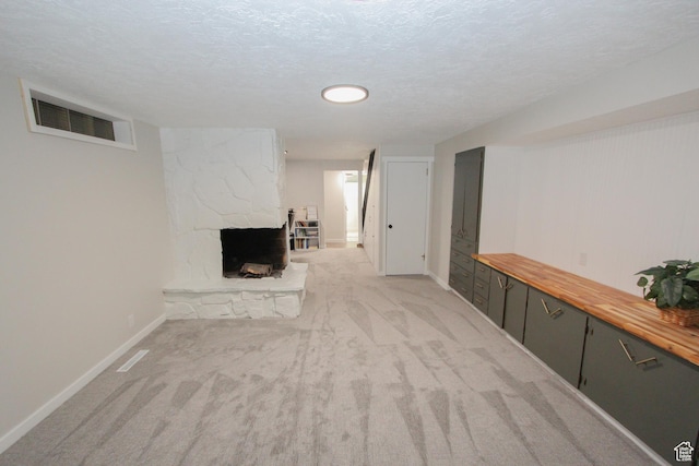 1460 E 2100 N, North Logan, UT 84341 - finished below grade area featuring a stone fireplace, baseboards, light carpet, and a textured ceiling