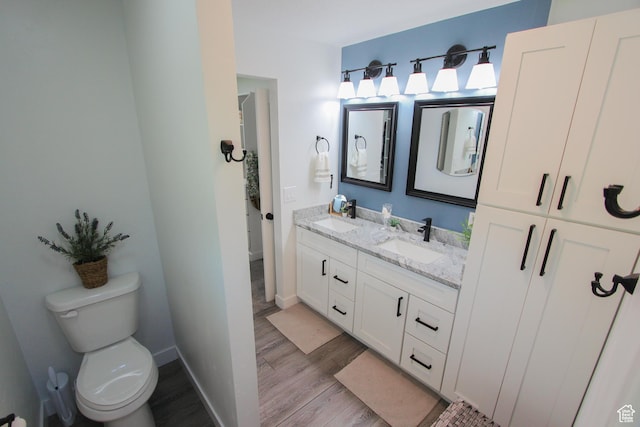 1460 E 2100 N, North Logan, UT 84341 - bathroom featuring wood finished floors, double vanity, toilet, and baseboards