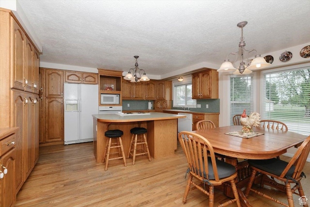 310 E Valley View Dr, Preston, ID 83263 - dining area with a chandelier, light wood-type flooring, and a textured ceiling